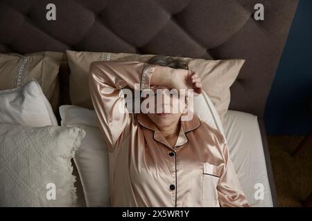 Une vieille femme insomnie, bouleversée, couchée dans son lit et souffrant d'insomnie Banque D'Images