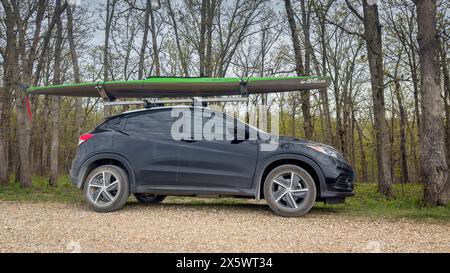 Rosebud, MO, États-Unis - 20 avril 2024 : kayak de course stellaire sur les galeries de toit du Honda HR-V SUV sur un parking forestier. Banque D'Images