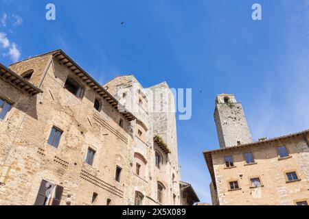 Une belle vue sur les célèbres tours de San Gimignano en Toscane, Italie par une journée ensoleillée avec un ciel bleu. Vu du rez-de-chaussée dans le centre historique. Banque D'Images