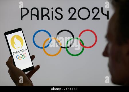 Bruxelles, Belgique. 11 mai 2024. Le logo des Jeux Olympiques de Paris est affiché sur un smartphone avec l'icône Jeux Olympiques de Paris 2024 visible en arrière-plan sur cette illustration photo. Prise à Bruxelles, Belgique. Le 11 mai 2024. (Jonathan Raa/Sipa USA) crédit : Sipa USA/Alamy Live News Banque D'Images