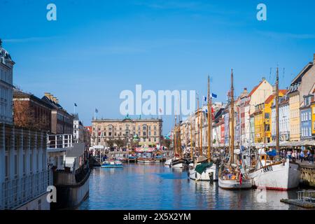 Copenhague, Danemark - 6 avril 2024 : front de mer bondé de Nyhavn, canal et quartier des divertissements à Copenhague, bordé par un câble historique aux couleurs vives Banque D'Images