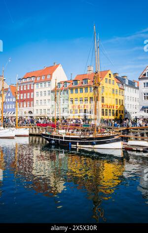 Copenhague, Danemark - 6 avril 2024 : front de mer bondé de Nyhavn, canal et quartier des divertissements à Copenhague, bordé par un câble historique aux couleurs vives Banque D'Images