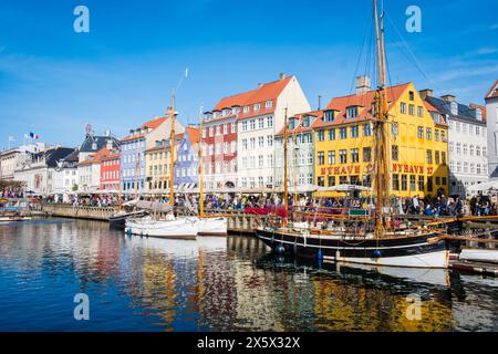 Copenhague, Danemark - 6 avril 2024 : front de mer bondé de Nyhavn, canal et quartier des divertissements à Copenhague, bordé par un câble historique aux couleurs vives Banque D'Images