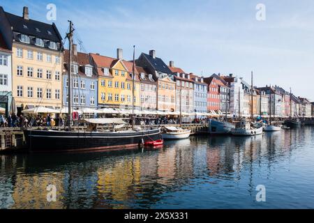 Copenhague, Danemark - 6 avril 2024 : front de mer bondé de Nyhavn, canal et quartier des divertissements à Copenhague, bordé par un câble historique aux couleurs vives Banque D'Images