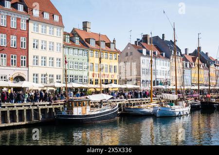 Copenhague, Danemark - 6 avril 2024 : front de mer bondé de Nyhavn, canal et quartier des divertissements à Copenhague, bordé par un câble historique aux couleurs vives Banque D'Images