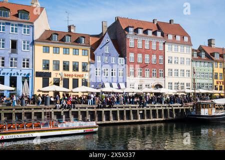 Copenhague, Danemark - 6 avril 2024 : front de mer bondé de Nyhavn, canal et quartier des divertissements à Copenhague, bordé par un câble historique aux couleurs vives Banque D'Images