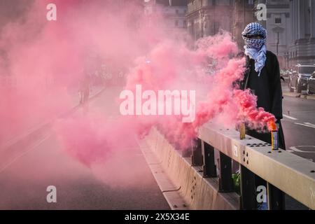 Westminster, Londres, Royaume-Uni. 11 mai 2024. Un manifestant en écharpe palestinienne se tient seul d'un côté du pont, avec une fusée rouge. La « manifestation d'urgence pour la Palestine », une collaboration entre Youth Demand, Health Workers for Palestine et plusieurs autres organisations, a bloqué le pont Waterloo à Londres. Des fusées de fumée et des manifestants en colère peuvent être vus. La manifestation avait débuté près du London Eye via la Southbank pour atteindre sa destination au pont. Crédit : Imageplotter/Alamy Live News Banque D'Images