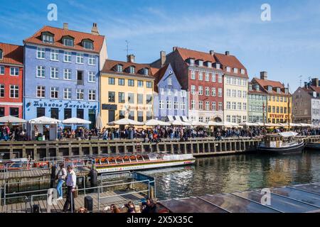 Copenhague, Danemark - 6 avril 2024 : front de mer bondé de Nyhavn, canal et quartier des divertissements à Copenhague, bordé par un câble historique aux couleurs vives Banque D'Images