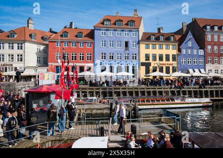 Copenhague, Danemark - 6 avril 2024 : front de mer bondé de Nyhavn, canal et quartier des divertissements à Copenhague, bordé par un câble historique aux couleurs vives Banque D'Images