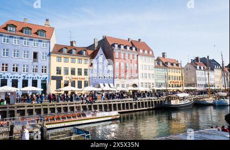 Copenhague, Danemark - 6 avril 2024 : front de mer bondé de Nyhavn, canal et quartier des divertissements à Copenhague, bordé par un câble historique aux couleurs vives Banque D'Images