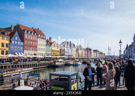 Copenhague, Danemark - 6 avril 2024 : front de mer bondé de Nyhavn, canal et quartier des divertissements à Copenhague, bordé par un câble historique aux couleurs vives Banque D'Images