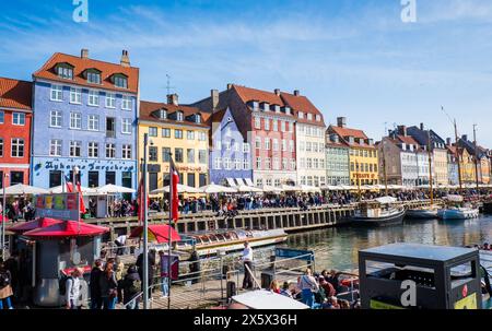 Copenhague, Danemark - 6 avril 2024 : front de mer bondé de Nyhavn, canal et quartier des divertissements à Copenhague, bordé par un câble historique aux couleurs vives Banque D'Images