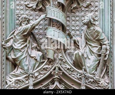 MILAN, ITALIE - 16 SEPTEMBRE 2024 : le détail de la porte principale en bronze de la cathédrale - réunissant Joseph et le roi David - par Ludovico Pogliaghi (1906). Banque D'Images