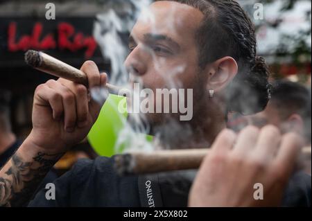 Madrid, Espagne. 11 mai 2024. Les gens fumant de gros joints de cannabis pendant la marche mondiale de la marijuana. Les gens marchent à travers le centre-ville pour exiger une loi pour la légalisation du cannabis. La Marche mondiale de la marijuana a lieu au début du mois de mai chaque année dans de nombreuses villes du monde entier. Crédit : Marcos del Mazo/Alamy Live News Banque D'Images