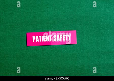 Mots relatifs à la sécurité du patient écrits sur un autocollant de papier rose avec fond vert. Symbole conceptuel de sécurité du patient. Copier l'espace. Banque D'Images