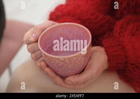 Mains féminines avec conception d'ongles blancs tenant le cacao dans une grande tasse, confortable, il y a de l'eau dans une tasse rose Banque D'Images