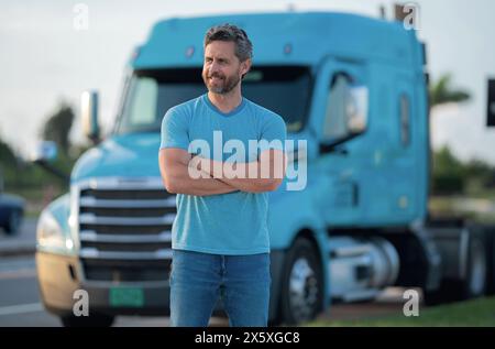 Conducteur homme près d'un camion. Homme propriétaire camion . Propriétaire sérieux d'un camion d'âge moyen. Véhicules de l'industrie du transport. Beau conducteur Banque D'Images