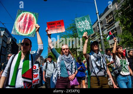 Amsterdam, pays-Bas. 11 mai 2024. Des manifestants sont vus tenir des pancartes pendant le rassemblement. Plusieurs organisations pro-palestiniennes ont organisé un rassemblement pendant le 76e anniversaire de la Journée de la Nakba dans le centre d’Amsterdam. Des milliers de personnes ont appelé à un cessez-le-feu dans la bande de Gaza, où le nombre de morts palestiniens est passé à 34 789. Les autorités sanitaires de Gaza ont déclaré dans un communiqué de presse. Crédit : SOPA images Limited/Alamy Live News Banque D'Images