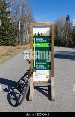 Vélo de montagne garé près de Bow Valley Cycling Experience Parc national Banff panneau indiquant les itinéraires et les distances dans les montagnes Rocheuses canadiennes Banque D'Images