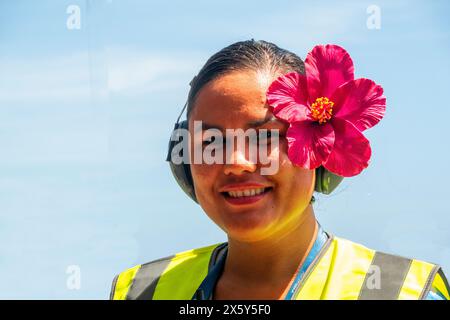 Portrait d'une jeune polynésienne souriante avec une fleur rouge derrière l'oreille, Polynésie française Banque D'Images