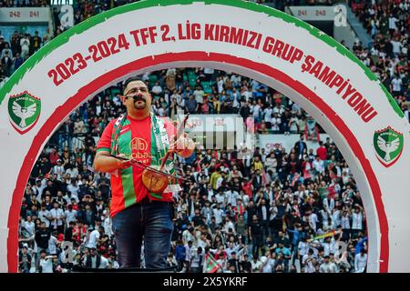 Diyarbakir, Turquie. 11 mai 2024. Le célèbre chanteur kurde Helim Omeri se produit lors de la cérémonie de la coupe. Amedspor, l'équipe de football de la ville de Diyarbakir, où vivent le plus les Kurdes de Turquie, a reçu la coupe du championnat du groupe Rouge de la 2ème Ligue lors d'un festival organisé au stade de Diyarbakir et auquel ont assisté des dizaines de milliers de fans. Amedspor a été promu dans la Fédération turque de football 1re Ligue après 12 ans en tant que champion dans son groupe. Amedspor est soutenu par une grande partie des Kurdes en Turquie et à l’étranger. Crédit : SOPA images Limited/Alamy Live News Banque D'Images