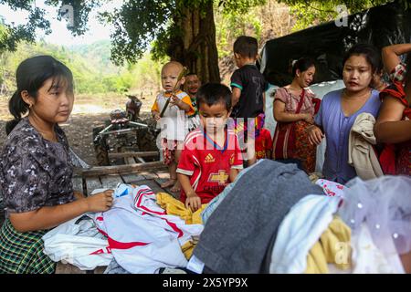 Myawaddy, Myanmar. 11 mai 2024. Les gens qui fuient la guerre de Myawaddy ont vu choisir des vêtements parmi les donateurs. Les réfugiés de guerre de Myawaddy vivent dans la forêt à cause de la guerre entre le groupe de résistance et l'armée birmane. L'armée birmane a utilisé des bombes à moteur et des frappes aériennes. Par conséquent, beaucoup de gens fuient l'endroit où ils vivaient. Certaines personnes qui pouvaient se permettre les charges coûteuses fuient à Mae sot, en Thaïlande. Mais pour les gens qui ne pouvaient pas se les permettre, ils vivaient dans la Jungle. (Photo de Kaung Zaw Hein/SOPA images/Sipa USA) crédit : Sipa USA/Alamy Live News Banque D'Images