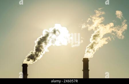 Usine avec cheminées et fumée. Un soleil brillant brille à travers la centrale électrique de la centrale de fumée. Contexte industriel Banque D'Images