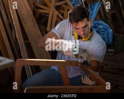 Charpentier professionnel heureux de travailler à la fabrication de meubles d'artisanat du bois dans l'atelier de bois look professionnel de haute compétence faisant des meubles. chefs-d'œuvre . Banque D'Images