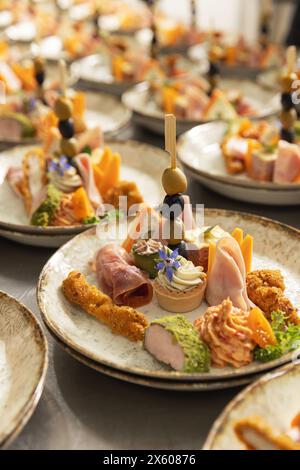 Canapés gourmands sur des assiettes décorées alignées pour un événement traiteur Banque D'Images