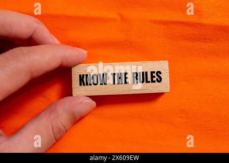 Connaître les mots de règles écrits sur bloc de bois avec fond orange. Conceptuel connaître le symbole des règles. Copier l'espace. Banque D'Images