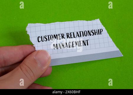 Mots de gestion de la relation client écrits sur du papier déchiré avec fond vert. Symbole conceptuel de gestion de la relation client. Copier l'espace. Banque D'Images