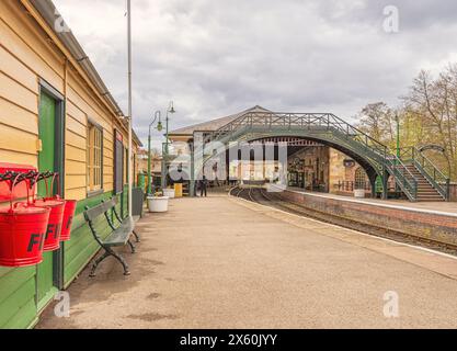 Une gare à thème du North Yorkshire Moors Railway à Pickering dans le North Yorkshire. Une cabane avec des seaux de feu sont au premier plan et un br Banque D'Images