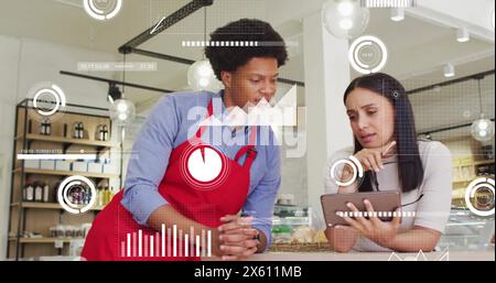 Image de plusieurs graphiques se déplaçant sur divers collègues discutant sur une tablette au bureau Banque D'Images