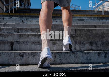 un homme monte les escaliers en haut Banque D'Images