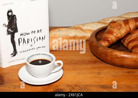 Réservez Comment être parisien, où que vous soyez. Par Sophie Mas, Audrey Diwan, Caroline de Maigret, Anne Berest. Thème avec baguette de croissant au café Banque D'Images