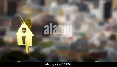 Image d'une porte-clés dorée et d'une clé, accrochée devant une vue floue sur la ville Banque D'Images