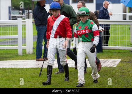 Windsor, Berkshire, Royaume-Uni. 6 mai 2024. Mari et femme jockeys, Tom Marquand et Hollie Doyle se dirigent vers le Parade Ring pour participer aux Mick and Joan Memorial handicap Stakes à l'hippodrome Royal Windsor au Family Fun Raceday lundi, jour férié Banque D'Images