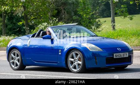 Milton Keynes, Royaume-Uni - 11 mai 2024 : 2006 voiture bleue Nissan 350Z à toit ouvert conduisant sur une route britannique Banque D'Images