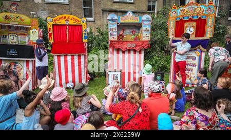 Londres, Royaume-Uni. 12 mai 2024. Enfants et adultes regardent un spectacle de l'un des membres de la Punch & Judy Fellowship. L'après-midi, un certain nombre de spectacles traditionnels et modernes de Punch et Judy divertissent la foule. Les marionnettistes de tout le pays se rassemblent pour le festival annuel de mai Fayre and Puppet. Il se déroule dans les jardins de l'église St Paul (également appelée église de l'acteur), Covent Garden et comprend un service religieux, une procession, des spectacles de Punch et Judy, des ateliers, des stands et des divertissements en famille. Crédit : Imageplotter/Alamy Live News Banque D'Images