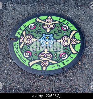 Kurashiki, Japon - 14 avril 2024 : Pokemon Utility Hole Cover sur le sol au Japon, photo Focus sur le couvercle de trou d'homme en acier pour le drainage Banque D'Images