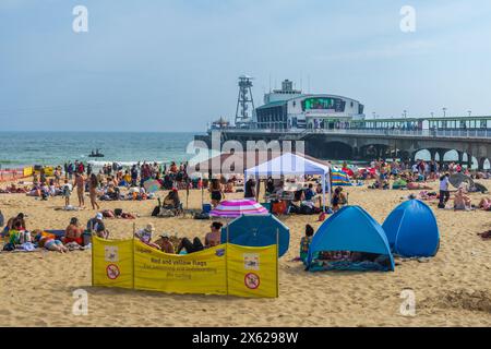 East Cliff Beach, Bournemouth, Royaume-Uni - 12 mai 2024 : bains de soleil sur la plage de sable en face de la jetée de Bournemouth. Banque D'Images