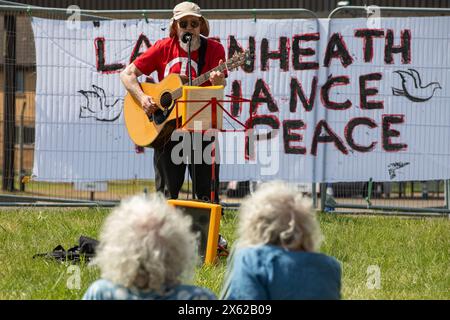 Lakenheath, Royaume-Uni. 11 mai 2024. Un musicien folklorique joue pour les partisans de la campagne pour le désarmement nucléaire (CND) lors d'une manifestation devant la porte principale de la RAF Lakenheath. Les manifestants ont appelé le gouvernement britannique à refuser la livraison de bombes nucléaires américaines B61-12 à la base et ont lu une déclaration demandant que la base et ses environs soient désignées comme zone exempte d'armes nucléaires. Il faisait partie d'une journée nationale d'action de la CND. Crédit : Mark Kerrison/Alamy Live News Banque D'Images