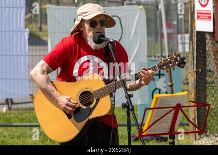 Lakenheath, Royaume-Uni. 11 mai 2024. Un musicien folklorique joue pour les partisans de la campagne pour le désarmement nucléaire (CND) lors d'une manifestation devant la porte principale de la RAF Lakenheath. Les manifestants ont appelé le gouvernement britannique à refuser la livraison de bombes nucléaires américaines B61-12 à la base et ont lu une déclaration demandant que la base et ses environs soient désignées comme zone exempte d'armes nucléaires. Il faisait partie d'une journée nationale d'action de la CND. Crédit : Mark Kerrison/Alamy Live News Banque D'Images