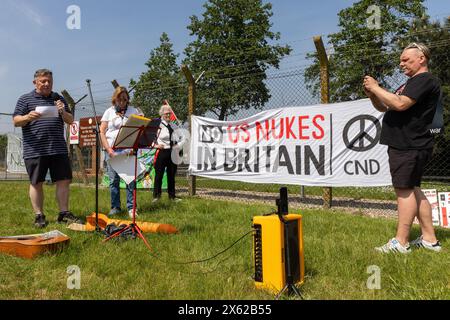 Lakenheath, Royaume-Uni. 11 mai 2024. Les résidents locaux manifestent devant la porte principale de la RAF Lakenheath. La manifestation organisée par la campagne pour le désarmement nucléaire (CND) et les résidents locaux a appelé le gouvernement britannique à refuser la livraison de bombes nucléaires américaines B61-12 à la base et a donné lecture d'une déclaration appelant à la désignation de la base et de ses environs comme zone exempte d'armes nucléaires. Il faisait partie d'une journée nationale d'action de la CND. Crédit : Mark Kerrison/Alamy Live News Banque D'Images