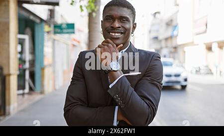 Homme africain confiant dans un costume élégant debout sur une rue de la ville urbaine. Banque D'Images