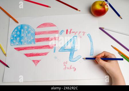 Le drapeau américain en forme de coeur avec l'inscription juillet 4 est dessiné avec des crayons par la main d'un enfant. Patriotisme, jour de l'indépendance, drapeau Banque D'Images