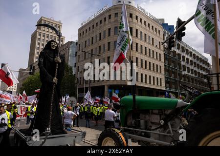 Varsovie, province de Mazovie, Pologne. 10 mai 2024. Un personnage représentant la mort est vu devant le Parlement européen à Varsovie, lors d'une manifestation contre le Green Deal de l'Union européenne à l'approche des élections législatives de l'UE, à Varsovie. La manifestation a été organisée par le syndicat autonome indépendant ''solidarité'', des agriculteurs, des mouvements de droite et anti-UE avec la participation de politiciens du droit et de la Justice et de la Confédération. (Crédit image : © Maciek Jazwiecki/ZUMA Press Wire) USAGE ÉDITORIAL SEULEMENT! Non destiné à UN USAGE commercial ! Banque D'Images