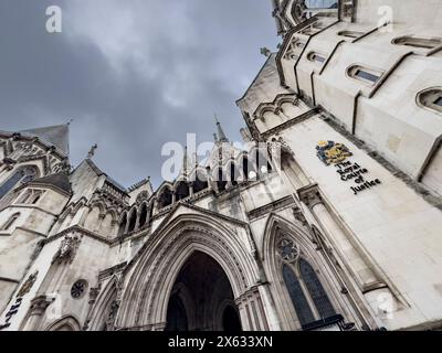 Vue extérieure de la Royal courts of Justice, Londres, prise sous un angle bas sur un ciel gris spectaculaire. Banque D'Images