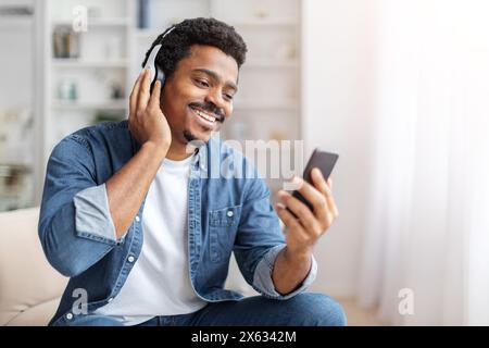 Homme portant des écouteurs parlant sur le téléphone portable Banque D'Images