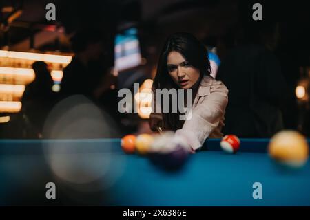 Amis joyeux appréciant une soirée amusante en jouant au billard dans un bar local Banque D'Images